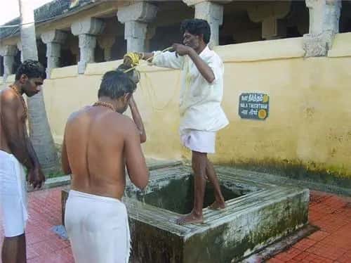 Pilgrim taking the sacred 22 Theertham holy well bath inside Ramanathaswamy Temple, Rameswaram